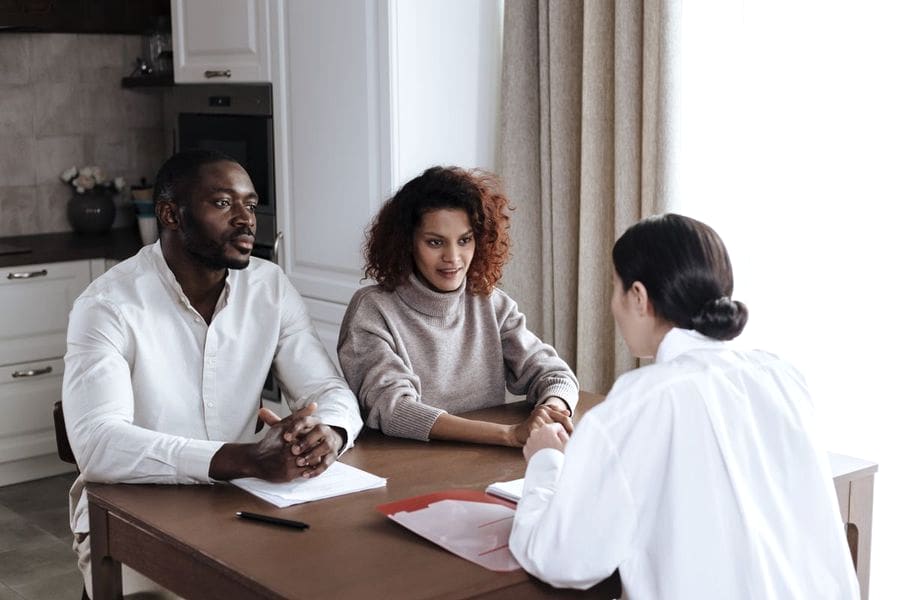 Trabajadora social entrevistando a una pareja durante una consulta familiar